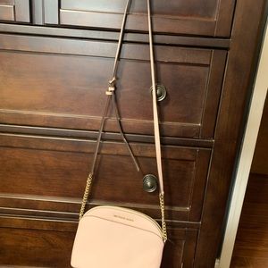 A light pink cross body. It’s is used. Has a small light mark on the front.